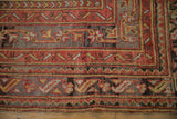 Hand-knotted texture of geometric borders in pomegranate red and slate blue on a vintage Oushak rug.