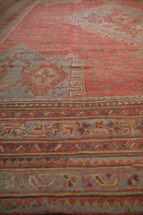 Angled view of the low-pile texture on a vintage Oushak's geometric border in red and slate.