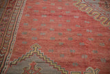 Starburst floral motifs and serrated geometric details on a vintage hand-knotted Turkish Oushak carpet.