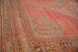 Angled view of the geometric border and low-pile texture on a vintage Oushak carpet.