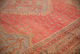 A vintage Oushak corner with a pomegranate red field, delicate abrash, and a geometric slate blue border.