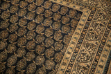 Antique Tabriz carpet: navy field with staggered finned boteh and checkered vine border detail.