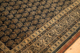 Close-up of antique Tabriz rug, navy boteh field, checkered vine and pawn borders.