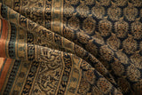 Folds reveal antique Tabriz carpet's navy and gold finned boteh pattern with rust border.