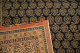 Antique Tabriz carpet: navy field, gold finned boteh, and rust pawn motif border.