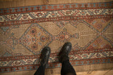 Antique Serab runner's low-pile texture, highlighting geometric medallions and serrated pawn motif borders.