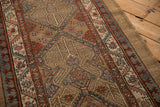 Angled view of the antique Serab runner's serrated leaf and pawn borders in camel, blue, and blush tones.
