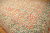 Detailed corner of distressed Mahal rug: brick red lotus border and dusty teal field.