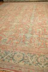 Distressed vintage Mahal carpet detail, worn curvilinear floral patterns in pale brick red, dusty teal.