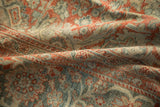 Close-up of distressed Mahal carpet with faded brick red and dusty teal floral patterns.