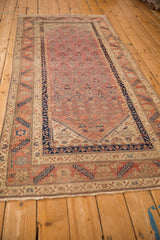 Angled view of an antique Malayer runner displaying its dynamic blush field and intricate border system.