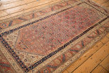 Angled view displaying the diagonal mapping of floral motifs on an antique Malayer rug runner.