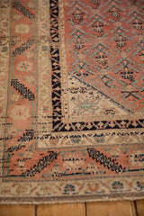 Intricate barber-pole and serrated leaf borders on a fine antique Malayer rug in blush and navy.