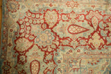 Distressed vintage Kashan rug showing prominent ivory floral boteh, red outlines, and sky blue details.