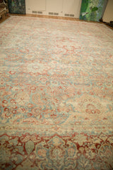 Distressed Persian Kashan rug showing muted sky blue and blush floral scrollwork detail.