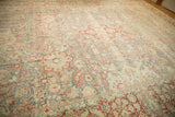 Distressed vintage Kashan carpet showing sky blue field, pomegranate floral boteh, and scrolled leaves.