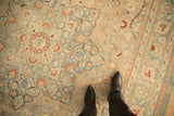 Even wear on a vintage Tabriz carpet highlighting scrolled vines in sky blue, sand, and burnt orange.