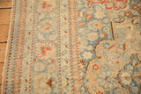 The low, worn pile and intricate pawn and vine borders of a distressed vintage Tabriz carpet.