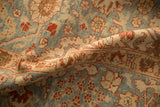 Softly worn pile of a distressed Tabriz rug with terra cotta and powder blue floral motifs.