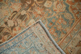 A folded corner of the distressed Mahal rug reveals its hand-knotted foundation and secured side cord.