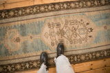Worn texture of a distressed Caucasian runner with blue and ivory geometric motifs.