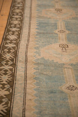 Angled view of a distressed runner's coffee brown geometric border and low-pile texture.
