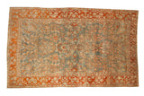 Antique distressed Sarouk carpet with allover floral sprays on a dusty blue field and a rich terracotta border.