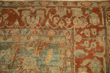 The floral vine border in deep terra cotta on an antique distressed Persian Sarouk carpet.