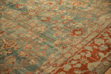 Detailed view of an antique Sarouk's low pile with terracotta floral sprays on a dusty sky blue field.