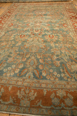 Low angle view along the short, distressed pile of a floral Sarouk carpet.