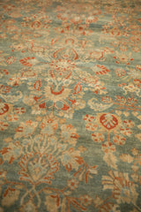 Angled close-up of the short, even pile of a distressed Sarouk with terracotta floral sprays.