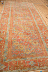 A long perspective view down the vintage Belouch runner, showing its geometric floral gul pattern.