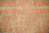 Evenly worn low pile showing hexagonal guls and a ribboned wave border in rust, gold, and powder blue.