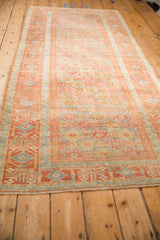 Angled view of a vintage Belouch runner showing its distressed geometric pattern and full length.