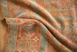 Folded corner of a distressed Belouch rug revealing the worn pile and intact side cord selvage.