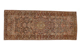 A vintage distressed Bakhtiari runner rug with a central medallion and scrolled arabesques in burgundy, charcoal, and blush.