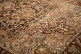 Angled detail of the distressed Bakhtiari rug's texture with visible scrolled arabesques.