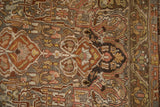 Time-softened low pile on a Bakhtiari rug showing scrolled arabesques and a serrated leaf border.