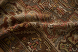 Distressed pile of a vintage Bakhtiari rug showing time-softened blush, brown, and charcoal tones.