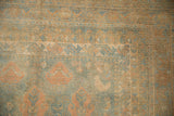 Close-up on the corner showing chicken motifs and a geometric border on a distressed Afshar rug.