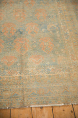 Angled close-up of the distressed Afshar rug's low pile, revealing apricot and powder blue motifs.