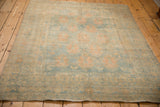 Angled perspective of the distressed Afshar rug's low pile and time-softened colors.