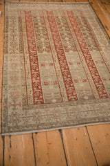 Angled perspective showing the decorative wear and striped pattern of a distressed Bijar rug.