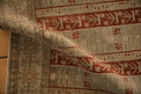 Folded view of a distressed Bijar rug showing the texture of its evenly worn, hand-knotted pile.