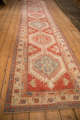 Long perspective on a vintage distressed Serab runner with repeating geometric medallions in red and blue.