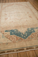 Angled view of the vintage Hamadan rug's distressed texture and serrated dusty blue medallion.