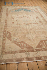 Perspective view of the distressed vintage Hamadan rug's low pile and soft neutral palette.