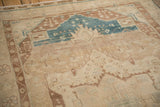 Angled view of a vintage Hamadan rug's serrated medallion and low-pile texture.