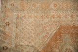 Interconnecting stepped outlines and boteh motifs with visible wear on a vintage Persian rug.