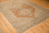 Distressed vintage Afshar rug showing worn texture across its geometric copper and dusty blue patterns.
